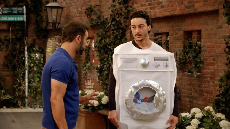 Elyas (Mehmet Daloğlu) muss für Mo (Yunus Cumartpay) Werbung für die Wäscherei machen. – Bild: NDR