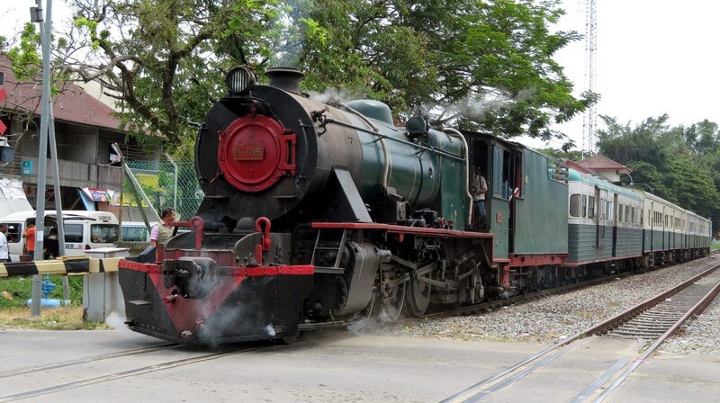 Eine Dampflok der englischen Vulcan Foundry aus den 50er Jahren steht vor den restaurierten Reisezugwagen der North Borneo Railway. – Bild: SWR/​Susanne Mayer-Hagmann