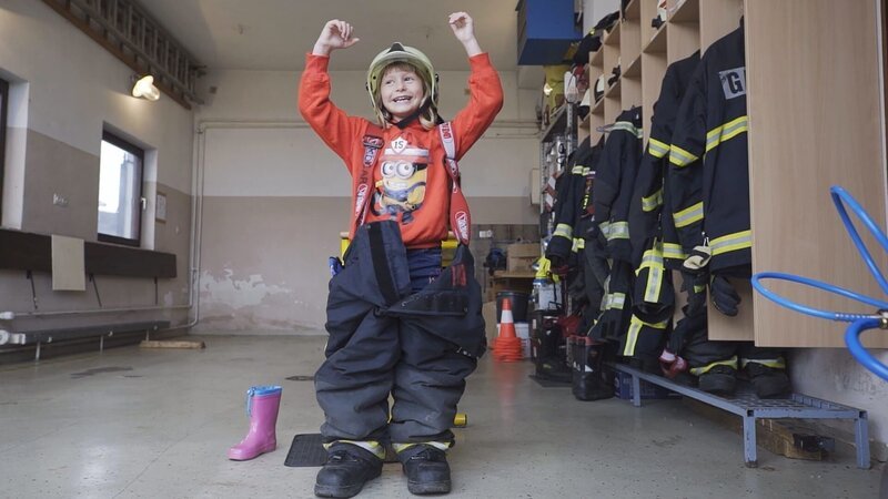 Katarina darf die Feuerwehrhose ihres Vaters anprobieren.Â – Bild: ZDF/​RTV Slovenia