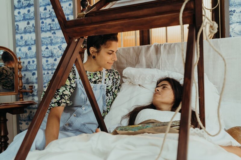 Da Frida Kahlo (Mina Sagdic) seit dem Busunfall das Bett nicht verlassen kann, malt sie liegend mithilfte eines Malgestells. – Bild: KiKA/​Sabine Finger