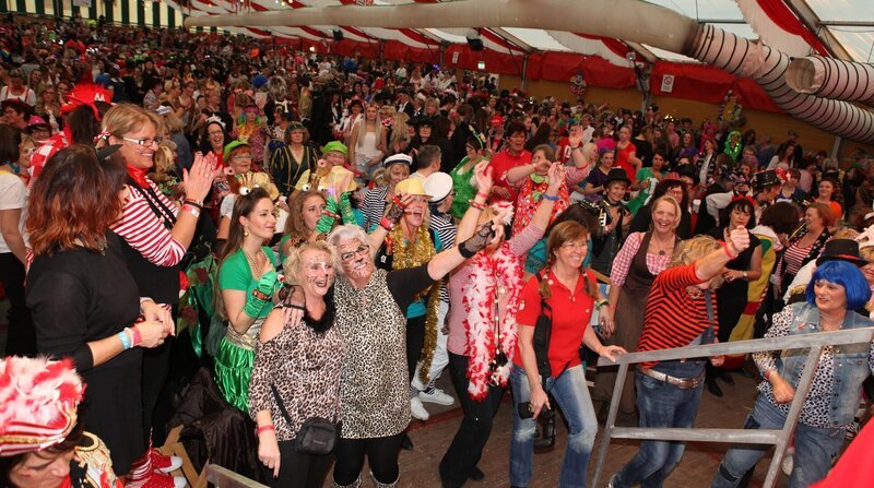 Vettweiß – hier lebt er, der echte, ehrliche und ursprüngliche Karneval auf dem Dorf. In jedem Jahr organisiert und feiert die Dorfgemeinschaft die „Hölle von Vettweiß“. Aus dem Örtchen wird eine jecke Party-Metropole. Über 10.000 Besucher innerhalb einer Woche. Ein Hauch von Wacken – dem Heavy-Metal-Mekka in Norddeutschland – weht dann in dem Dorf in der Voreifel. Am beliebtesten sind die Damensitzungen. Rund 2.000 Besucherinnen strömen täglich in das Festzelt auf dem Schulhof. Sie kommen nicht nur aus der Umgebung, sondern mittlerweile auch aus Belgien, dem Ruhrgebiet sowie Nord- und Süddeutschland. Das gebotene Programm ist hochkarätig: Brings, Kasalla, Paveier, Klüngelköpp, Räuber, Marita Köllner, Höhner, aber auch Büttenredner wie Martin Schopps, treten auf und begeistern die Damen. – Bild: WDR/​Sibylle Anneck