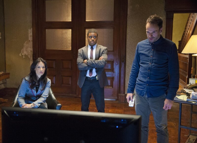 Als eine Bombe in den Büroräumen einer Firma hochgeht und zwei Opfer fordert, beginnt Sherlock Holmes (Jonny Lee Miller, r.) gemeinsam mit Joan Watson (Lucy Liu, l.) und Detective Marcus Bell (Jon Michael Hill, M.) mit den Ermittlungen … – Bild: CBS Television Lizenzbild frei