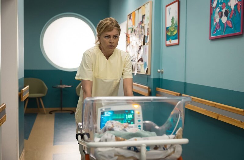 Dr. Ina Schulte (Isabell Gerschke) muss trotz eines bewaffneten Mannes und strengem Regelwerk, die Räume nicht zu verlassen, ein Baby auf die Neonatologie bringen. – Bild: MDR /​ Rudolf Wernicke