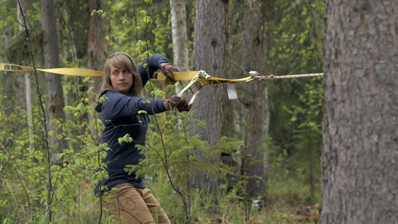 Jessi Morse kurbelt beim Fällen eines Baums an einem Gurtzeug (National Geographic). – Bild: National Geographic