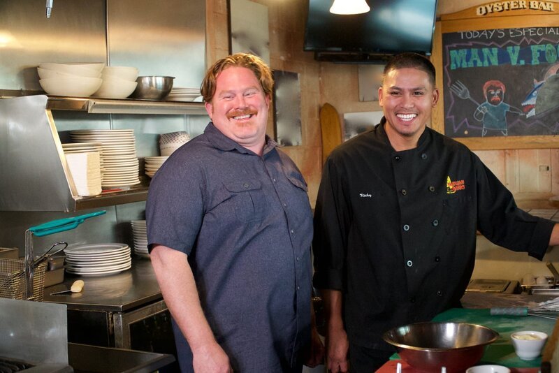 Host Casey Webb hangs with chef Ricky Baxa in the kitchen at Shanghai Red’s. – Bild: 2016, HGTV /​ Scripps Networks, LLC. All Rights Reserved