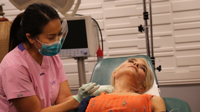 Dr. Sandra Lee performs surgery to remove Juliet’s lumps while she holds a mirror. – Bild: Discovery Communications, LLC