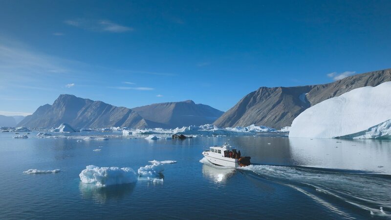 Das Teamboot auf offener See, umgeben von Eisbergen. (Bildnachweis: National Geographic/​Pablo Durana) – Bild: National Geographic/​Pablo Durana /​ National Geographic /​ Pablo Durana
