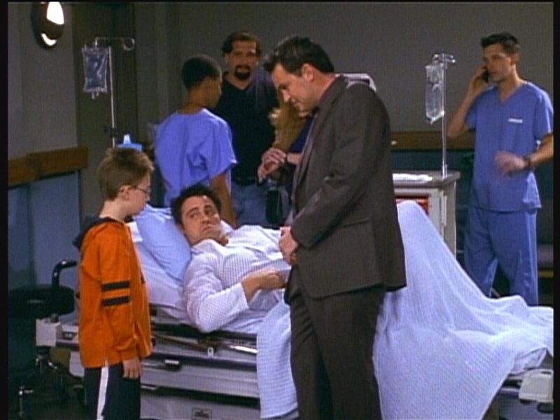 Joey (Matt LeBlanc, liegend) dreht unter Schmerzen eine Szene mit einem Kind, das ständig seinen Text vergisst. – Bild: ProSieben