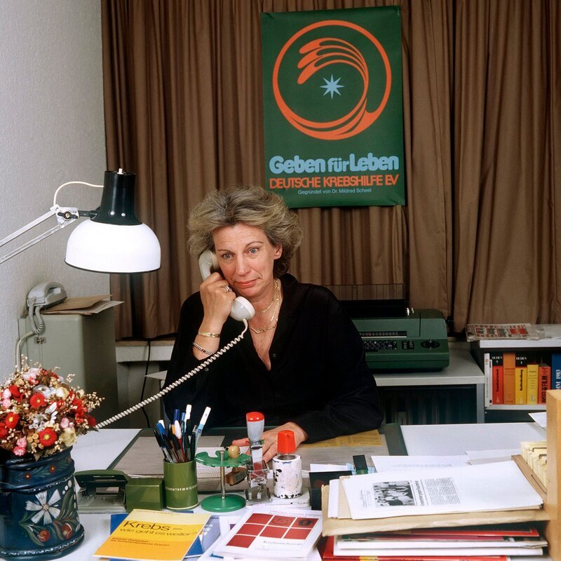 Die Dokumentation „Mildred Scheel – Die First Lady und der Kampf gegen den Krebs“ erzählt die Lebensgeschichte einer durchsetzungsstarken und mutigen Pionierin. Der Film gewährt mit bisher unveröffentlichten Privatfotos Einblicke in das Familienleben von Mildred Scheel. (Die Präsidentin der „Deutschen Krebshilfe e.V. „ Mildred Scheel, aufgenommen am 20. Juni 1983 in ihrem Büro in Köln). – Bild: WDR/dpa Die Dokumentation „Mildred Scheel – Die First Lady und der Kampf gegen den Krebs“ erzählt die Lebensgeschichte einer durchsetzungsstarken und mutigen Pionierin. Der Film gewährt mit bisher unveröffentlichten Privatfotos Einblicke in das Familienleben von Mildred Scheel. (Die Präsidentin der „Deutschen Krebshilfe e.V. „ Mildred Scheel, aufgenommen am 20. Juni 1983 in ihrem Büro in Köln). – Bild: WDR/dpa