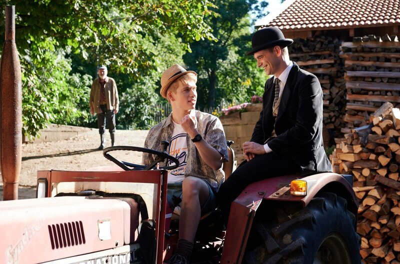 Joe Bend (James Chalmers) erklärt Pan Tau (Matt Edwards) den Traktor. – Bild: WDR/​ARD/​Caligari/​Film2020