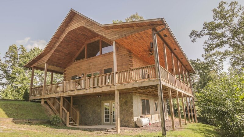 The exterior of the Deep Creek Cabin shows a large wrap-around deck and detailed woodwork, as seen on Log Cabin Living. – Bild: 2014,HGTV/​Scripps Networks, LLC. All Rights Reserved
