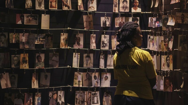 A visitor looks at the photo exhibit at the Kigali Genocide Memorial, which documents the 1994 Genocide against the Tutsi population in Rwanda. – Bild: Discovery Channel /​ Discovery Communications