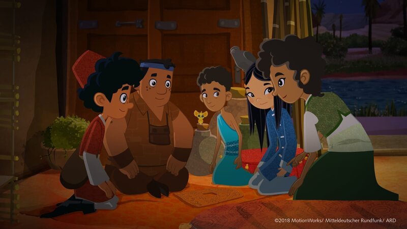 Marco, Luigi und Shi La haben das zerbrochene Puzzle wieder zusammengesetzt. Mejay (rechts) kann nun den alten ägyptischen Text darauf entziffern: Es ist eine Wegbeschreibung zum Grab des Kind-Königs Tutanchamun! – Bild: MDR/​ARD/​MotionWorks 2018