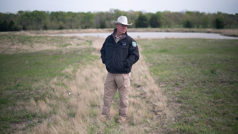 Warden Benny Richards standing in the field. – Bild: Animal Planet /​ Discovery Communications, LLC