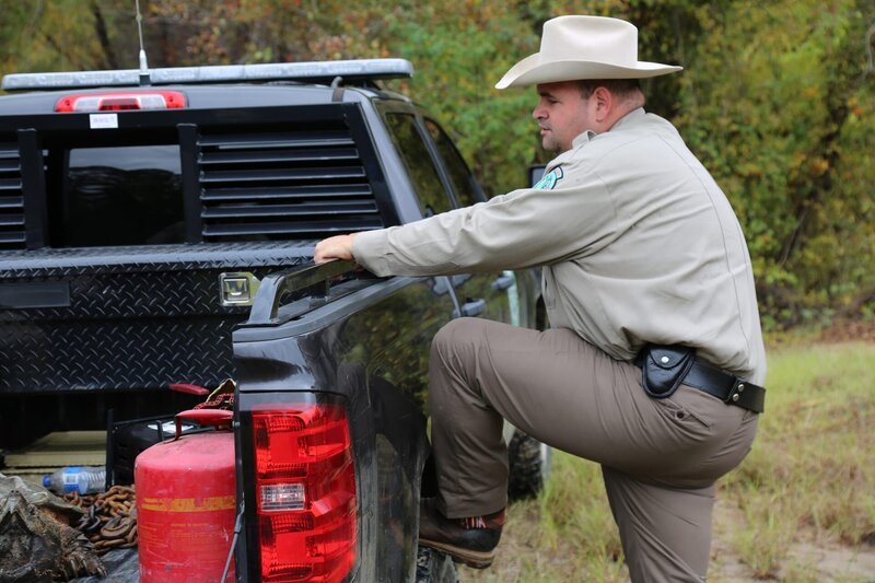 Warden Justin Eddins with his leg up on the truck’s rear tire. – Bild: Animal Planet /​ Discovery Communications, LLC