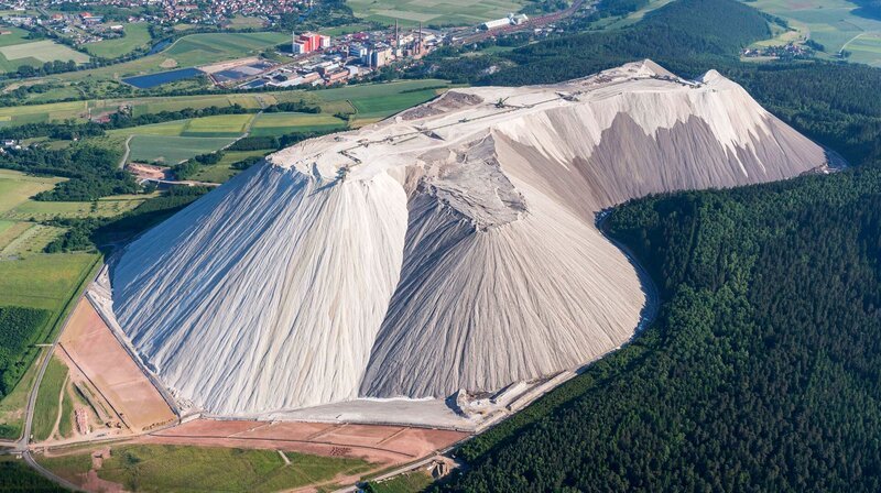 Ziemlich in der Mitte von Deutschland ragt er empor – der Monte Kali. Ganz in Weiß – der größte künstliche Berg hierzulande. Es sind aufgeschüttete Kalisalze aus dem Bergbau, die ihn auf rund 520 Meter haben wachsen lassen. – Bild: WDR/​imago/​imagebroker