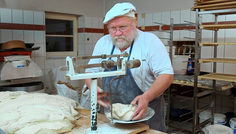 Altbewährt: Mit einer „römischen“ Schnellwaage portioniert Bäckermeister Günther Weber die einzelnen Laibe seines Bauernbrotes. – Bild: SWR