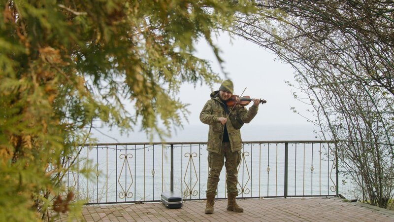 kulturMontag – Kulturkrieg – Kunst als Waffe – Mit ihrem enormen Widerstandswillen gegen den russischen Angriffskrieg hat die Ukraine die Welt überrascht. Dabei kommen Kunst und Kultur eine besondere Bedeutung zu. Denn der Krieg wird auch geführt als Krieg der Narrative und der Informationen. Dabei ist sowohl das ukrainische Nationalgefühl als auch die Kunst stärker geworden, je länger der Krieg dauert. Regisseur Philipp Kohlhöfer begleitet in der Dokumentation „Kulturkrieg – Kunst als Waffe“ ukrainische Künstler*innen vom Konzertsaal an die Front, vom Bunker ins Atelier und zeichnet ein eindrucksvolles Bild ihrer Kämpfe für ihre Kultur und ihr Überleben als Staat. Im Film treten u.a. die Band BoomBox um Sänger Andriy Khlyvnyuk und sowie Antytila mit Frontmann Taras Topolia auf. Auch First Lady Olena Selenska spricht über die Rolle der ukrainischen Kultur in diesem Krieg. – Im Bild: Moisei Bondarenko ist ukrainischer Musiker und Geiger. Mit Beginn des Krieges schloss sich Moisei den Streitkräften der Ukraine an. An der Front spielt er weiter Geige, um den Menschen in der Ukraine Kraft und Hoffnung zu geben. Foto: ORF/​BROADVIEW TV/​SPACE Productions/​Alex Lamakh. Veröffentlichung honorarfrei nur für redaktionelle Berichterstattung in Sendungszusammenhang und mit Copyrightangabe. Kontakt: foto@orf.at – Bild: ORF/​BROADVIEW TV/​SPACE Productions/​Alex Lamakh