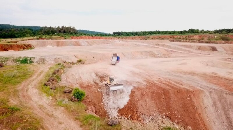 Ein stillgelegter Steinbruch bei Wetzlar wird mit Schutt verfüllt. Bittere Ironie: Wo zuerst die Landschaft zerstört wurde, wird jetzt auch mit ihrer Wiederherstellung Geld verdient. – Bild: HR