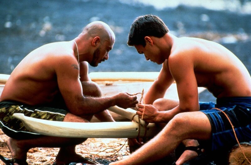 Jason (Jason Mamoa, r.) muss das Kanu, das er auf dem Big Island abholen soll, erst bauen! Kumu Pono (Keone Young, l.), der beste Bootsbauer unter den Bewohnern Hawaiis, erklärt ihm die Handhabung des „primitiven“ Werkzeugs … – Bild: Universal TV