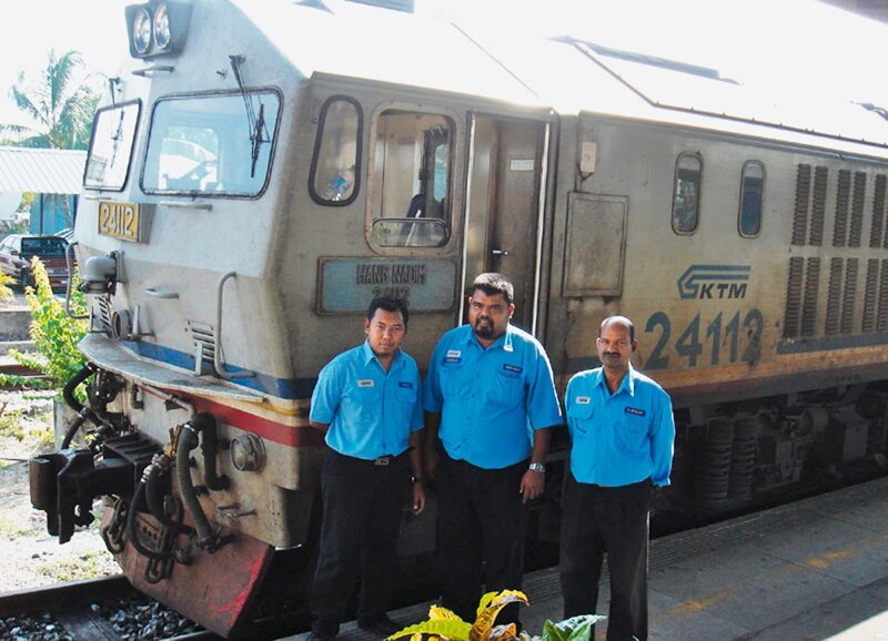 Das Zugführerteam des Eastern and Oriental Express in Malaysia – Halil, Mohd Foad und Murthy wissen zwar nicht, welche Lok sie genau fahren, aber ihren Angaben nach hat die aus Ungarn stammende Dieselmaschine 1700 PS und fährt bis zu 90 km/​h. – Bild: ZDF und SF