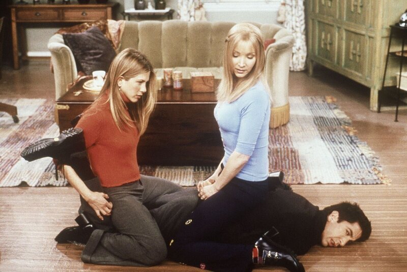 Der am Boden liegende Ross (David Schwimmer, unten) erklärt Phoebe (Lisa Kudrow, r.) und Rachel (Jennifer Aniston, l.), dass die Kunst der Selbstverteidigung im Kopf beginnt. – Bild: ProSieben Media AG