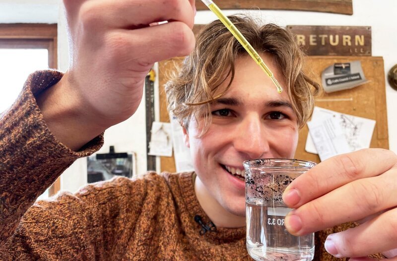 Erfinder Fionn Ferreira in seinem Labor in seiner Heimatort Ballydehob (Südwestirland). Aus Olivenöl und Magnetpulver stellt einen Stoff her, mit dem sich Mikroplastik aus Flüssigkeiten entfernen lässt. – Bild: MDR/​Vanessa Materla