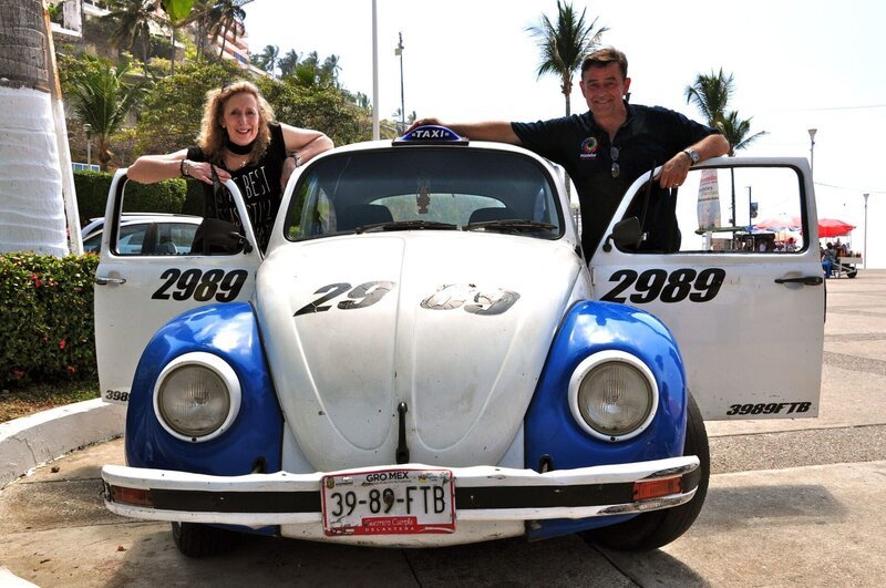 Entertainerin Kiona und Kreuzfahrtdirektor Thomas Gleiß posieren an einem alten VW Käfer in Acapulco, Mexiko. – Bild: BR/​Christian Hattesen