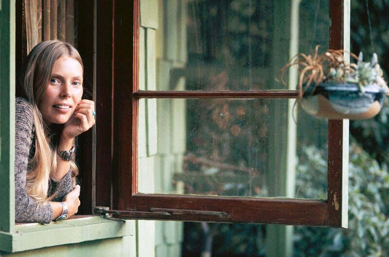 Joni Mitchell am Fenster ihres Hauses in Laurel Canyon, einem Viertel in Los Angeles, im Jahr 1970 – Bild: Henri Diltz /​ © Henri Diltz