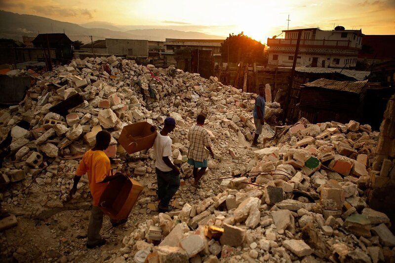 Männer bewegen sich auf der Suche nach verwertbaren Baumaterialien durch den zusammengebrochenen Marktplatz entlang der Grand Rue, einem der ältesten Geschäftsviertel der Hauptstadt, am 20. Februar 2010 in Port-au-Prince, Haiti. Mehr als einen Monat nach dem Erdbeben von 7,0, das viele Menschen in Port-au-Prince zerstörte, werden dauerhaftere Bauwerke aus Holz errichtet, um das Risiko von Überschwemmungen vor der Regenzeit zu bewahren. – Bild: Autentic GmbH/​BR/​Getty Images/​Chip Somodevilla/​Chip Somodevilla