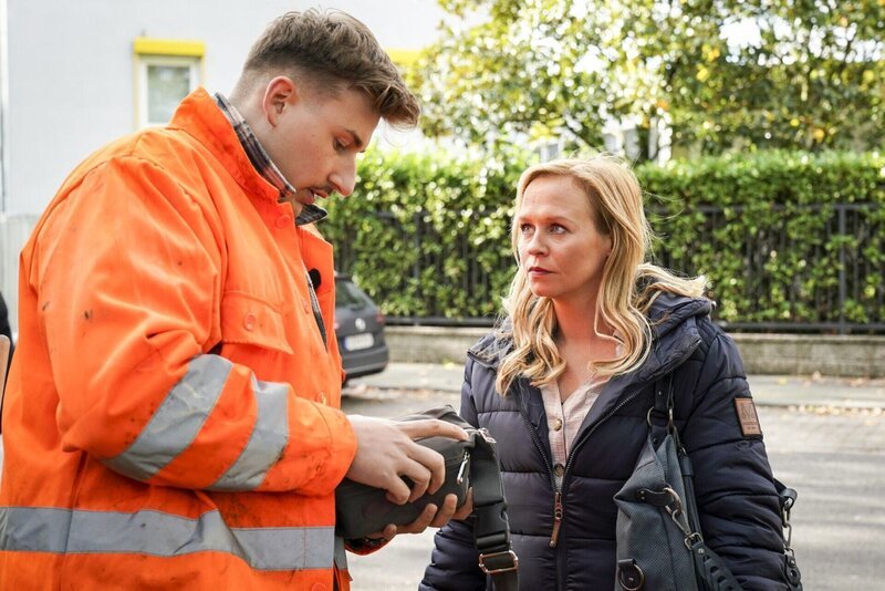 Kathi (Mandy Neidig) kommt fast zu spät und kann den Straßenkehrer (Timo Groesdonk) nur mit Mühe davon überzeugen, dass die Tasche ihr gehört. – Bild: RTL /​ Dennis Hundt