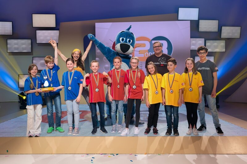 Von links: Team Blau mit dem Piet-Flosse-Pokal, Ulla Lohmann, Team Rot, Piet Flosse, Team Gelb, Moderator Elton und Kamerakind Matthias. – Bild: ZDF und Ralf Wilschewski.