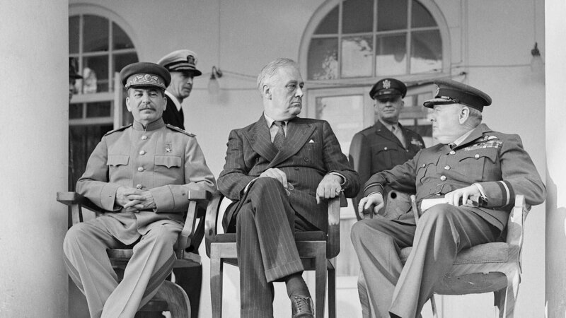 Joseph Stalin, Franklin D. Roosevelt und Winston Churchill auf der Veranda der sowjetischen Gesandtschaft in Teheran. – Bild: RTL/​ (c) Public Domain – UK Crown Copyright Expired