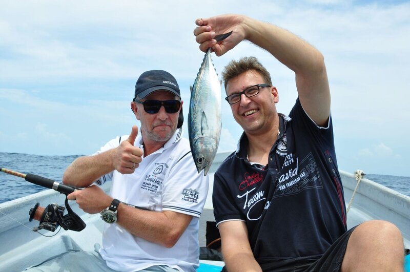 Stellvertretender Kreuzfahrtdirektor Jörn Hofer und Kapitän Morten Hansen posieren mit einem gefangenen Fisch – Bild: BR/​Christian Hattesen