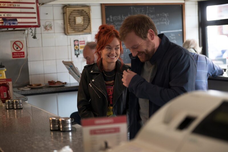 Lloyd (Stephen Jones) und Áine (Elva Trill) frühstücken in Lloyds Lieblings-Coffeeshop. – Bild: ZDF und Deadpan Pictures.