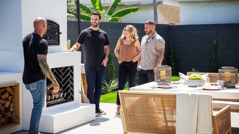 Host Mike Pyle(Left) shows homeowners Michael and Katie their new backyard’s patio and outdoor oven, as seen on Inside Out, Season 2. – Bild: Warner Bros. Discovery