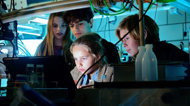 Alice (Emilia), Tarun (Casper), Clari (Charlotte) und Jonny (Leander) versuchen, im Labor des Instituts für Meeresforschung zu verstehen, woran Jaswinder gerade arbeitet. – Bild: NDR/​Letterbox/​Aidan Monaghan