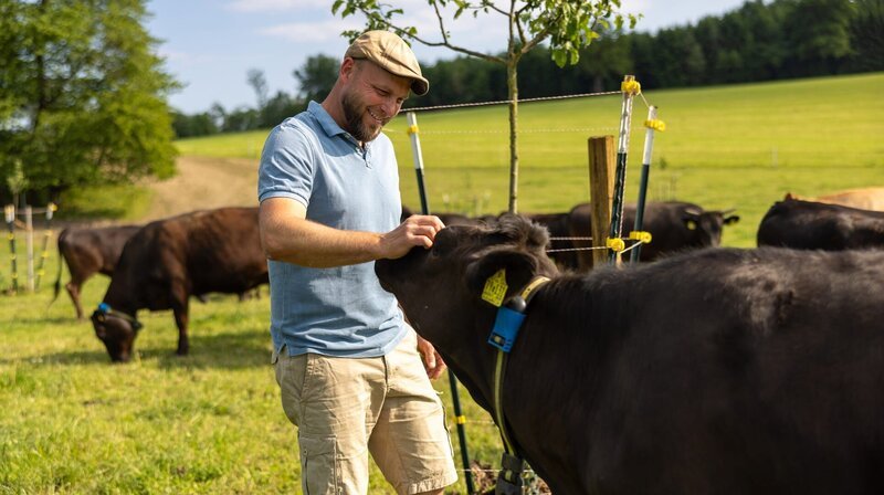 Georg Mayerhofer baut den Elektro-Weidezaun für seine Wagyu-Rinder auf. – Bild: NDR/​BR/​Ludwig Noack