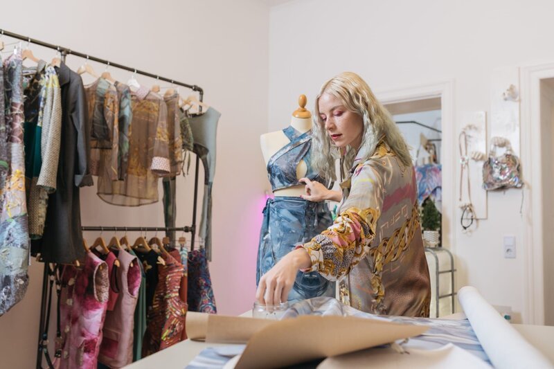 In ihrem Atelier und Laden in Berlin-Friedrichshain kreiert Jana Heinemann fertige Stücke und ganze Kollektionen, die verschiedene Stoffe, Drucke und Stile kombinieren. Nachhaltigkeit ist ihr dabei wichtig. – Bild: ZDF und Silviu Guiman.