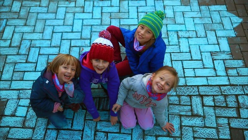 Kinder malen mit blauer Straßenkreide den Bürgersteig an. – Bild: WDR