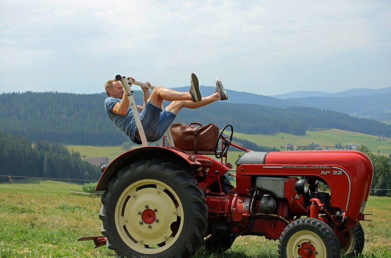 Der Trecker als Turngerät: Moderator Sven Tietzer zeigt seinen bekannten Aufschwung auf dem Haberjockelshof bei Titisee-Neustadt-Neustadt, wo er im August am Bulldog-Festival teilgenommen hat. – Bild: SWR/​cineteam Hannover