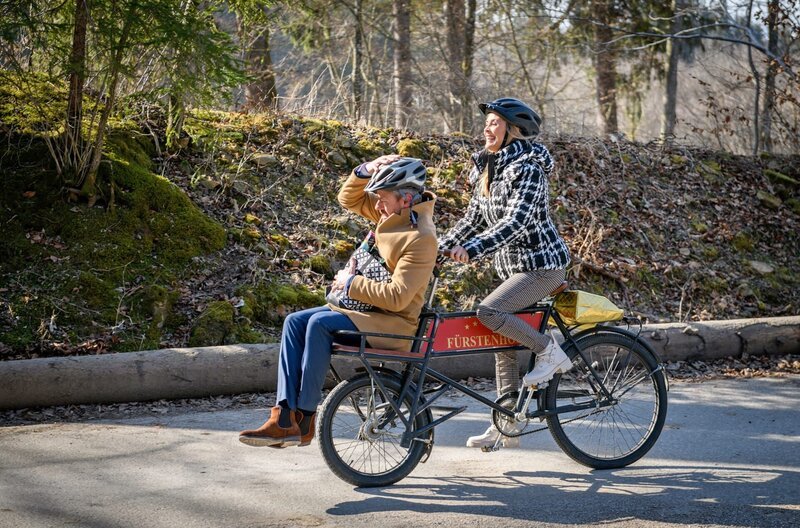 Yvonne (Tanja Lanäus, r.) holt Erik (Sven Waasner, l.) kurzerhand mit dem Fahrrad ab, als dieser Josies Überraschungsfeier zu verpassen droht. – Bild: ARD/​Christof Arnold