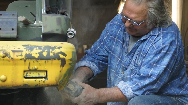 Der Mechaniker poliert das Metallteil. – Bild: Warner Bros. Discovery