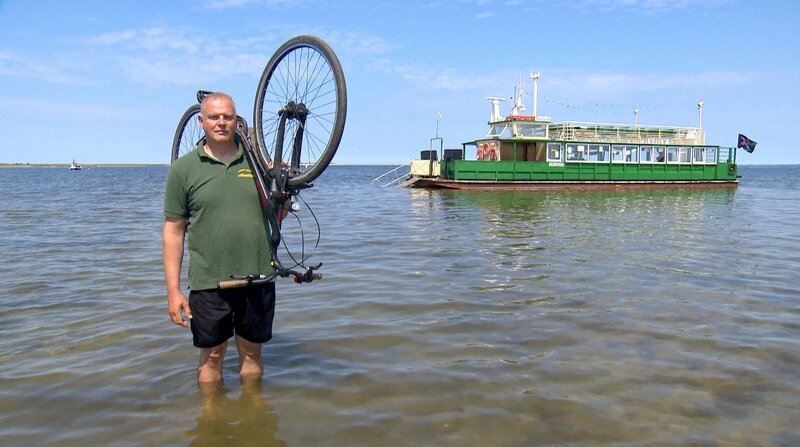 Abkürzung mit Hindernissen: Nils Steußloff steuert eine Fähre mit Fahrradfahrer übers Salzhaff. Von Rerik auf die Insel Poel … aber am Ufer wartet leider kein Hafen. – Bild: ZDF und NDR.