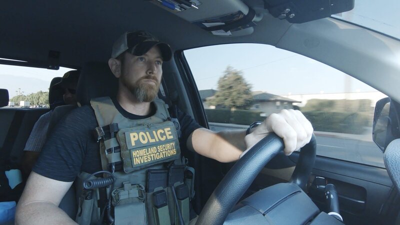 HSI Agent Connor driving his vehicle while wearing a bulletproof police vest. (Credit: National Geographic) – Bild: National Geographic /​ National Geographic
