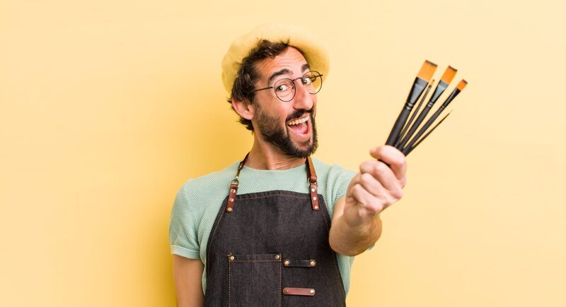 young crazy artist with brushes and wearing an apron and a beret – Bild: Shutterstock /​ Shutterstock /​ Copyright (c) 2022 Kues/​Shutterstock. No use without permission.