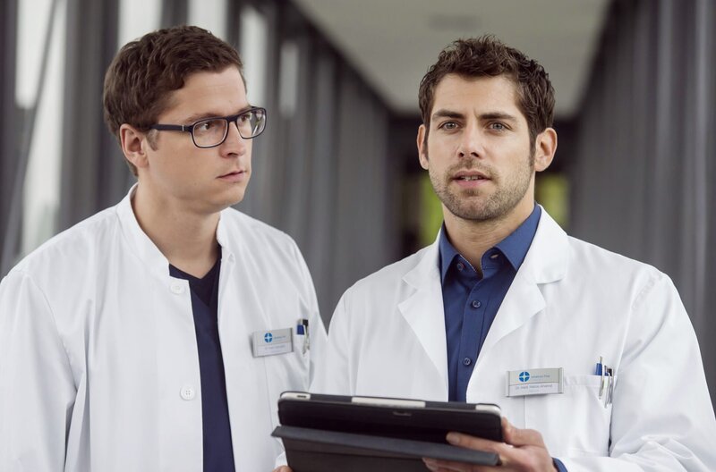 Elias (Stefan Ruppe, links) und Niklas (Roy Peter Link) schauen sich die Ergebnisse ihres Patienten an. Sie wissen noch nicht was ihm fehlt. – Bild: ARD/​BR/​Jens Ulrich Koch