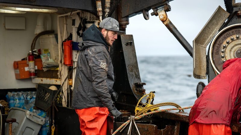 Aleutian Lady deckhand Eli at the rail. – Bild: Discovery Channel /​ Discover Images: DDCTC1921_1921 /​ © 2023 Warner Bros. Discovery, Inc. or its subsidiaries and affiliates. All rights reserved.