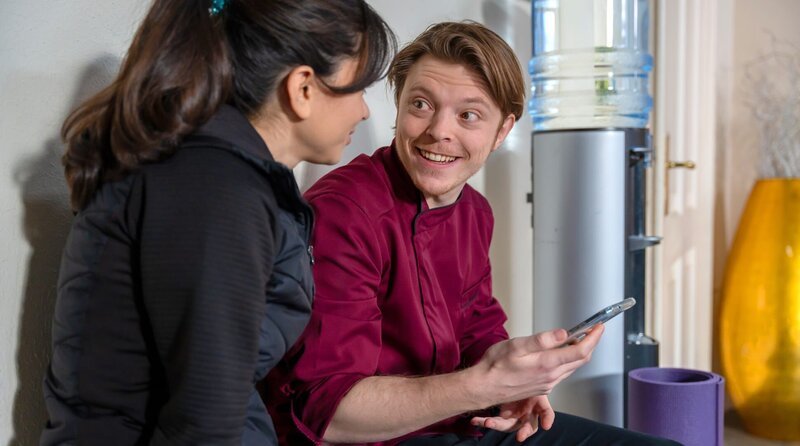 Theo (Lukas Leibe, r. mit Yeliz Simsek, l.) freut sich, als seine App von einem Onlinedienst im Sortiment aufgenommen wird. – Bild: ARD/​WDR/​Thomas Neumeier