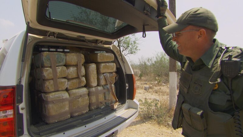 Brownsville, TX, USA: A U.S. Border Patrol agent looks at confiscated bundles filling up the back of his vehicle. – Bild: 2015 National Geographic Partners, LLC. All rights reserved. Lizenzbild frei
